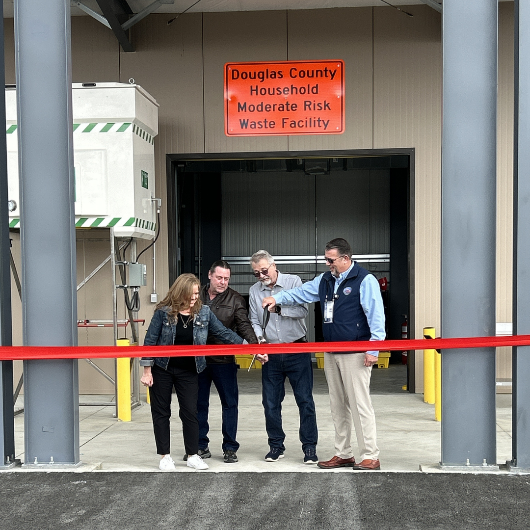 People cutting a large ribbon