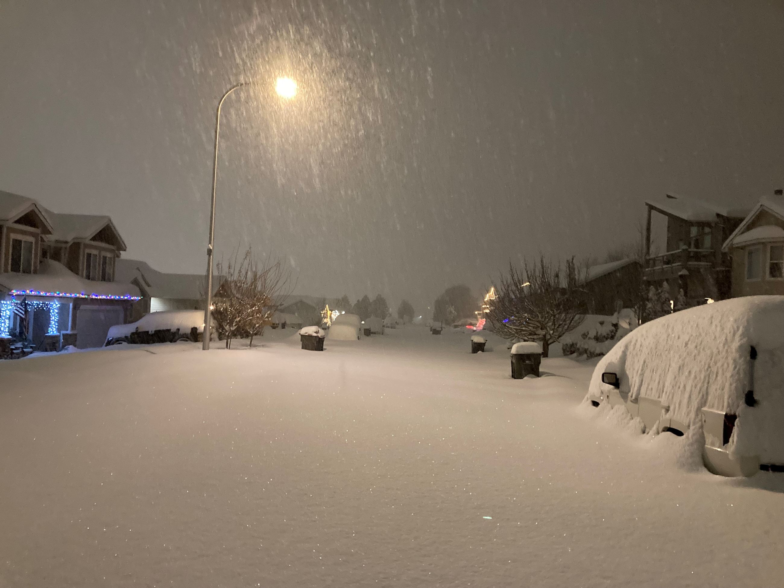 street and house with snow falling